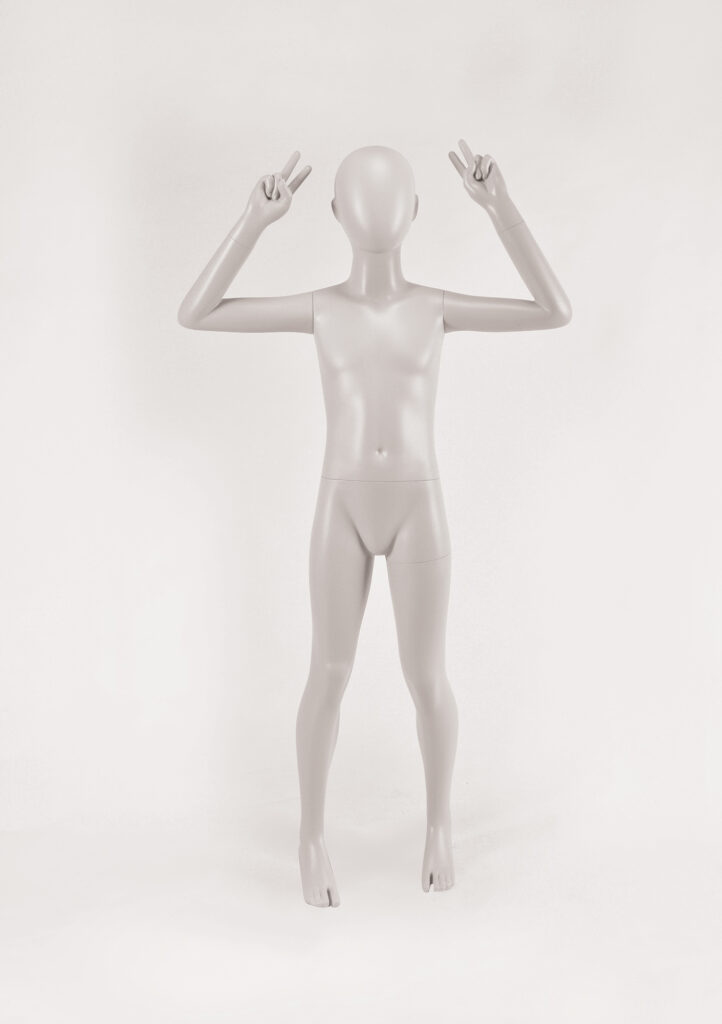 Mannequin by HOL A featureless, gray mannequin stands on a white background. The FK14 mannequin is posed with both hands raised near its head, each hand forming a peace sign gesture. The Farringdon Kids mannequin is bald and has no facial features or clothing.