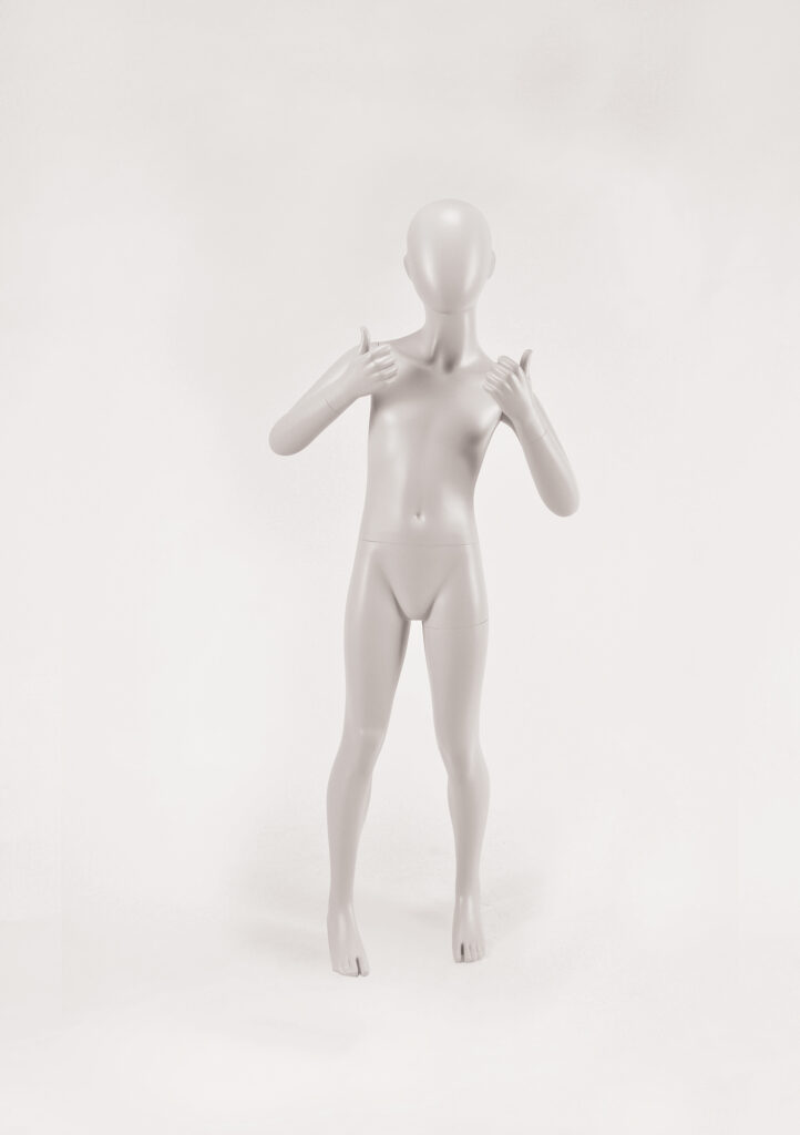 Mannequin by HOL A grey, featureless child mannequin, resembling the FK19 model from Farringdon Kids, stands on a white background. The mannequin has a smooth, undefined face and hair and is giving a double thumbs-up gesture with both hands.